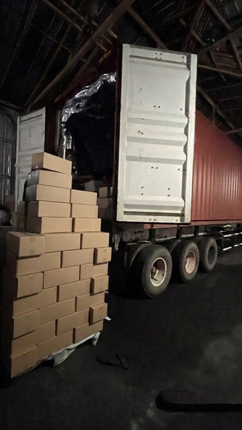Master cartons of charcoal staged beside an open container for loading